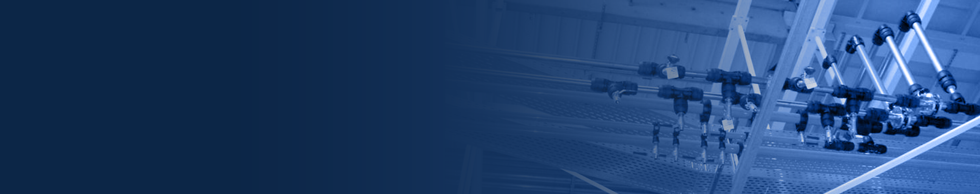 row of piping hung in a factory ceiling with a heavy gradient blue overlay