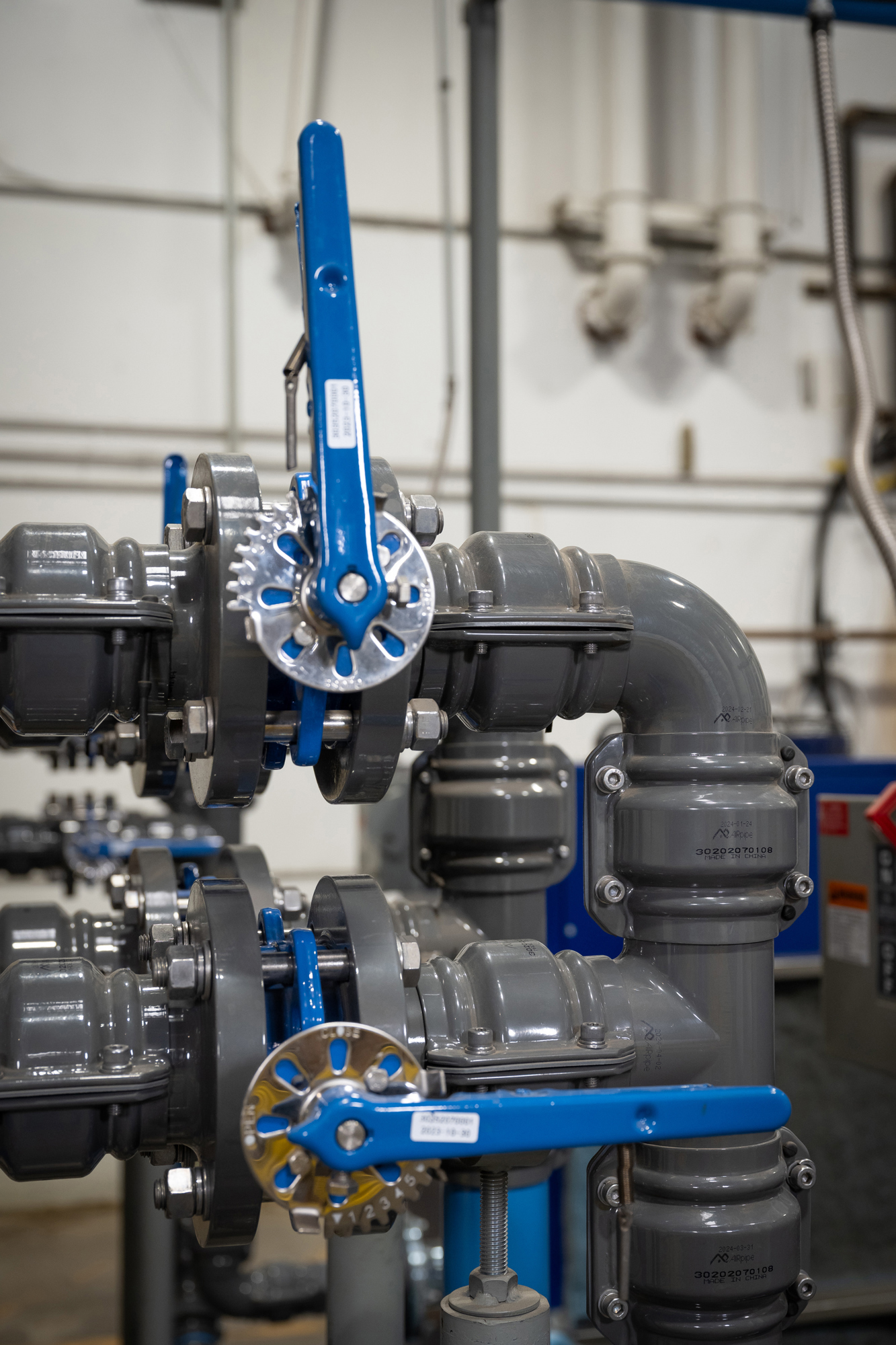 piping arrangement on factory floor with two large ball valves with blue handles