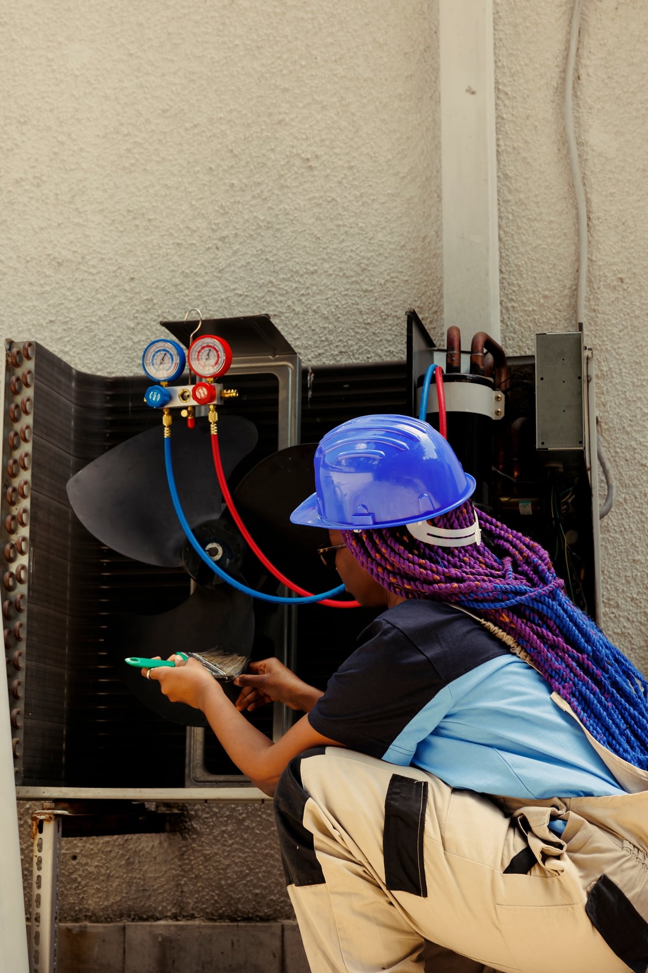 Technician in full PPE kneeling in front of some compressed air equipment